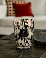 Baobab Pearls Black Classique na stoliku w salonie, szkło z czarnymi drobinkami na tle sofy z czerwoną poduszką
